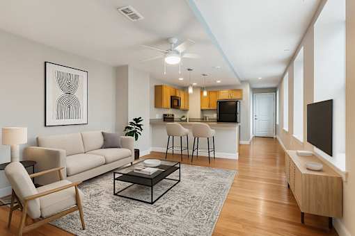 A living room with a grey rug and a white sofa.