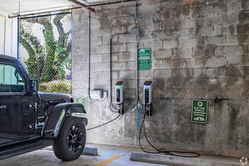 A black Jeep is charging at an electric vehicle charging station.