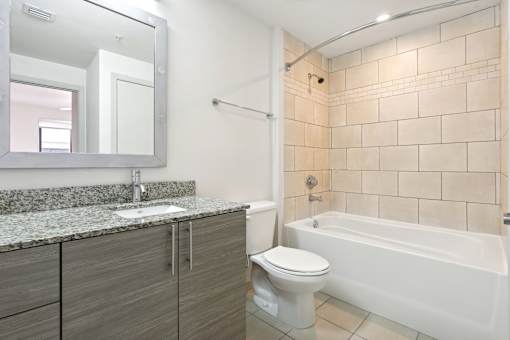 A bathroom with a white tub, sink, and toilet.