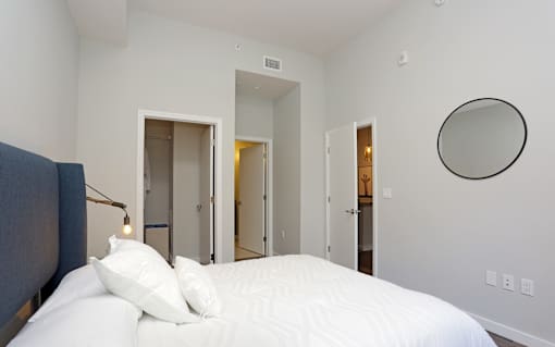 A bedroom with a large bed and a mirror on the wall.