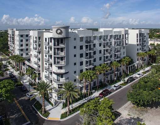 A white apartment building with a Q on the top.