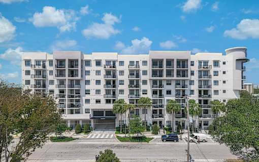 A large white building with a parking lot in front.