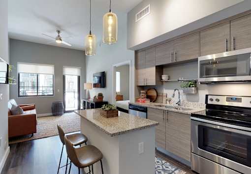 A modern kitchen with a large island and a dining area.