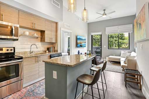 A modern kitchen with a large island and a dining area.