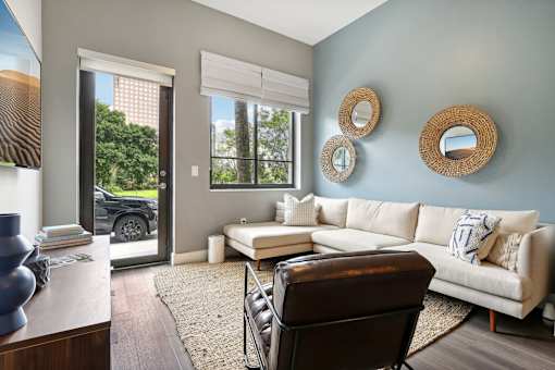 A living room with a white couch and a brown chair.
