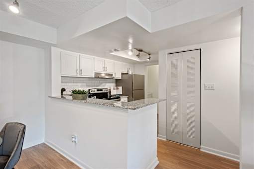 A kitchen with white cabinets and a counter.
