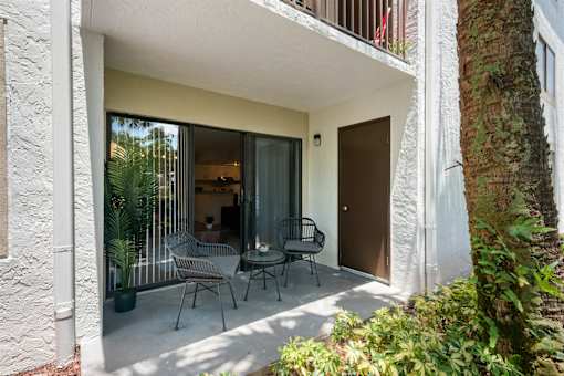 A patio with a table and chairs is seen through a doorway.