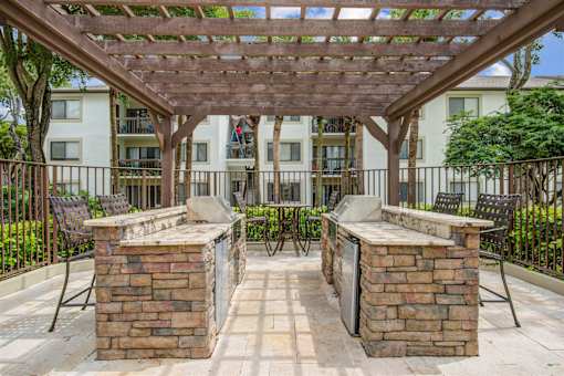 A patio with a pergola and two brick pillars.