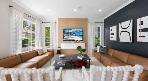 A modern living room with a large TV and comfortable seating.
