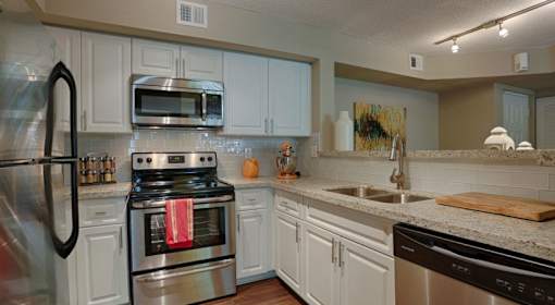 A kitchen with white cabinets and stainless steel appliances.