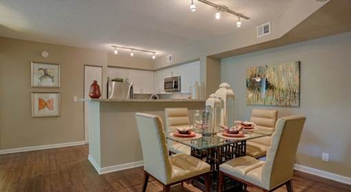 A dining room with a glass table and chairs.