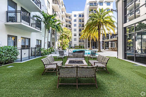 A patio with a table and chairs surrounded by buildings.