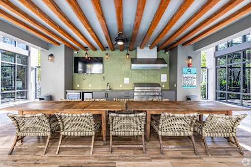 A wooden table surrounded by chairs under a striped ceiling.