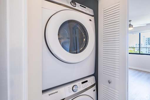 A white Samsung washing machine in a modern laundry room.