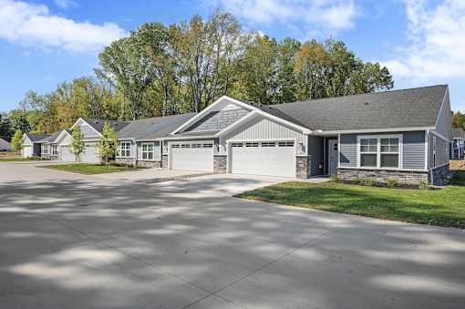 A house with a grey roof and a driveway in front.