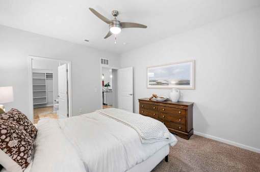 A spacious bedroom with a modern ceiling fan.