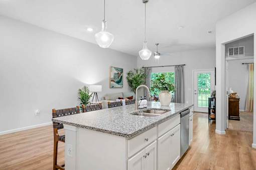 A kitchen with a granite countertop and white cabinets.