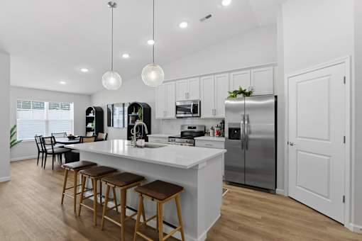 A modern kitchen with a white countertop and stainless steel appliances.