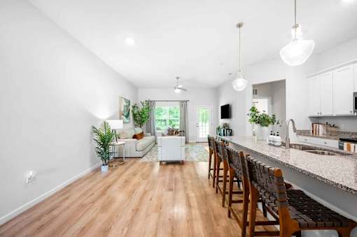 An open floor plan apartment home with seating at the kitchen island.