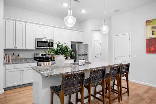 A kitchen with a granite countertop and white cabinets.