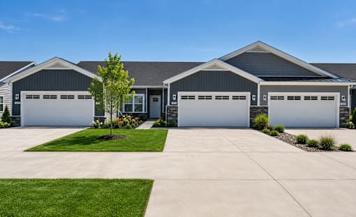 A large house with two garages and a driveway.