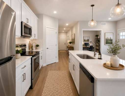 A modern kitchen with white cabinets and stainless steel appliances.