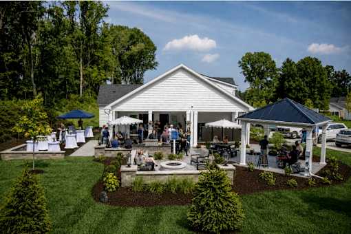 A white house with a porch and a garden in front.