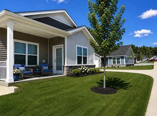 A house with a grey siding and a white porch.