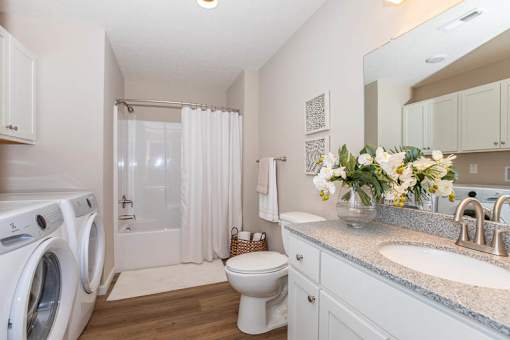 A white bathroom with a washer and dryer.
