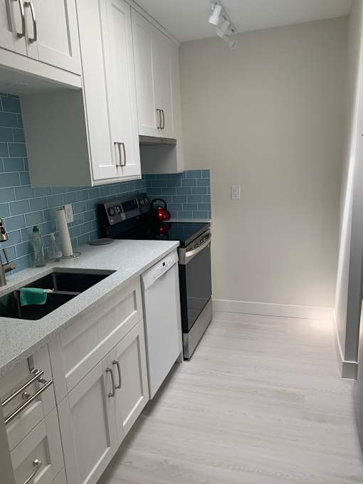A kitchen under construction with unfinished cabinets and a countertop.