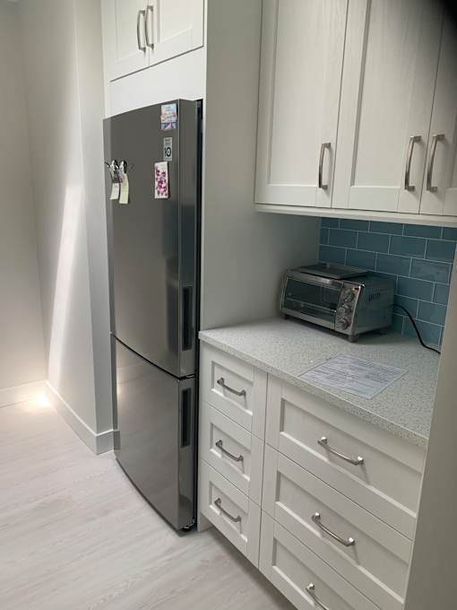 A kitchen with white cabinets and a stainless steel dishwasher.