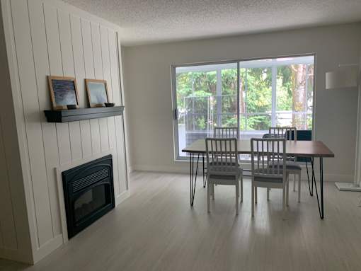 A room with a fireplace and a table with chairs.