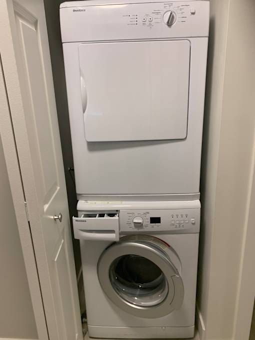 A white microwave oven with a white washing machine next to it.