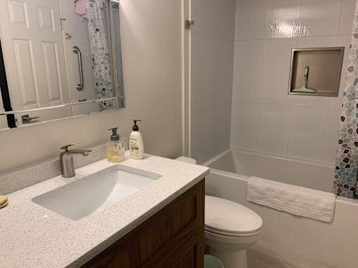 A white sink in a bathroom with a toilet and a mirror.