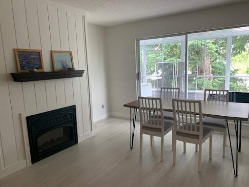 A room with a fireplace and a table with chairs.