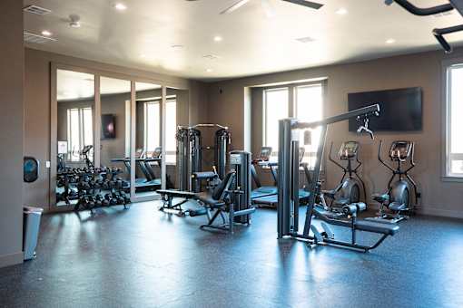 A gym with a variety of equipment including treadmills, weights, and exercise machines.at Eastpark Apartment Homes, Salem, OR 97301