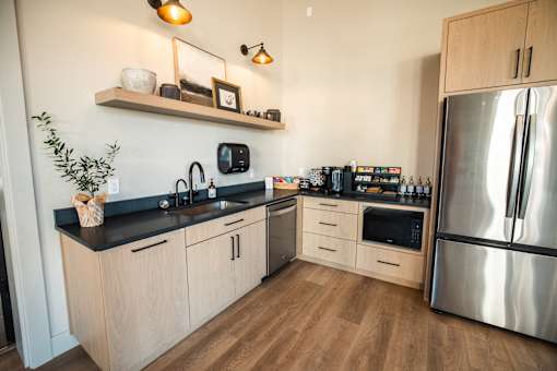 A modern kitchen with wooden cabinets and a stainless steel refrigerator.at Eastpark Apartment Homes, Salem
