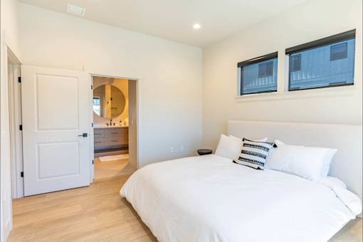 A bedroom with a large bed and a mirror on the wall.