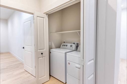 A white laundry room with a washer and dryer in it.