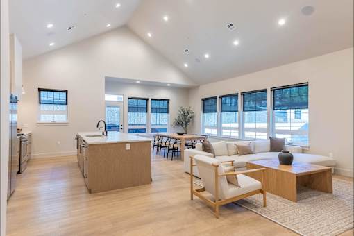 A spacious kitchen with a dining area and a living room with a couch and a coffee table.