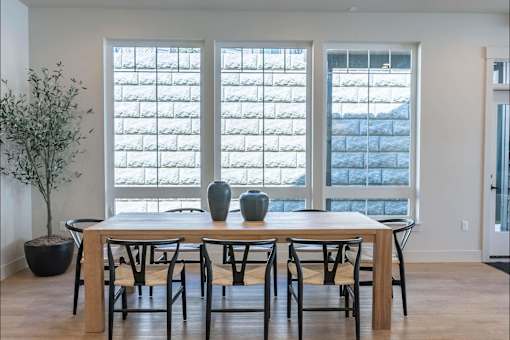 A dining room with a table and chairs.