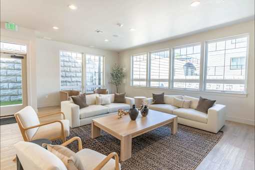 A living room with a white couch, a wooden coffee table, and a chair.