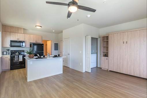 A kitchen with a white island and wooden floors.