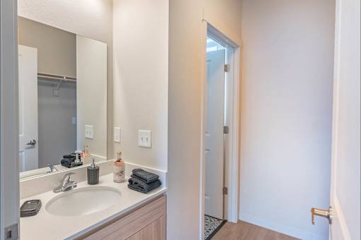 A bathroom with a sink, mirror, and towel.