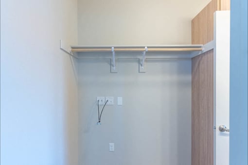 A white wall with a shelf and a door.