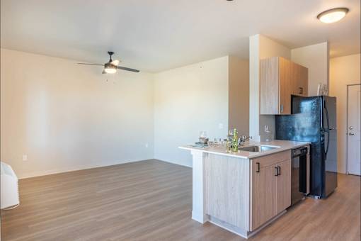A kitchen with a black fridge and a wooden counter.