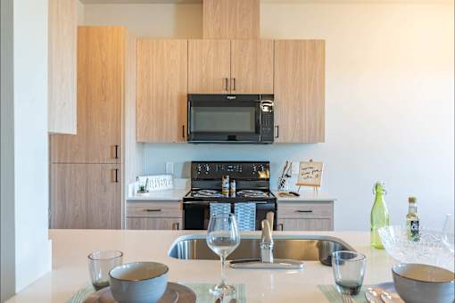A kitchen with a sink, microwave, and oven.