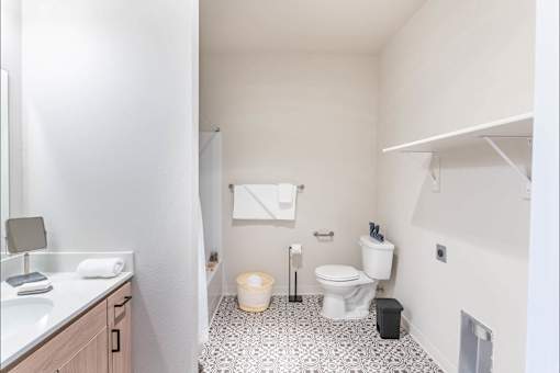 A white bathroom with a toilet, sink, and trash can.