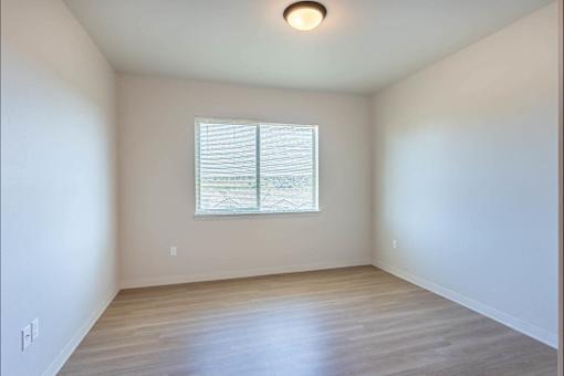 A room with a window and wooden flooring.