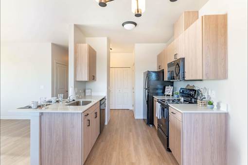 A kitchen with wooden cabinets and black appliances.